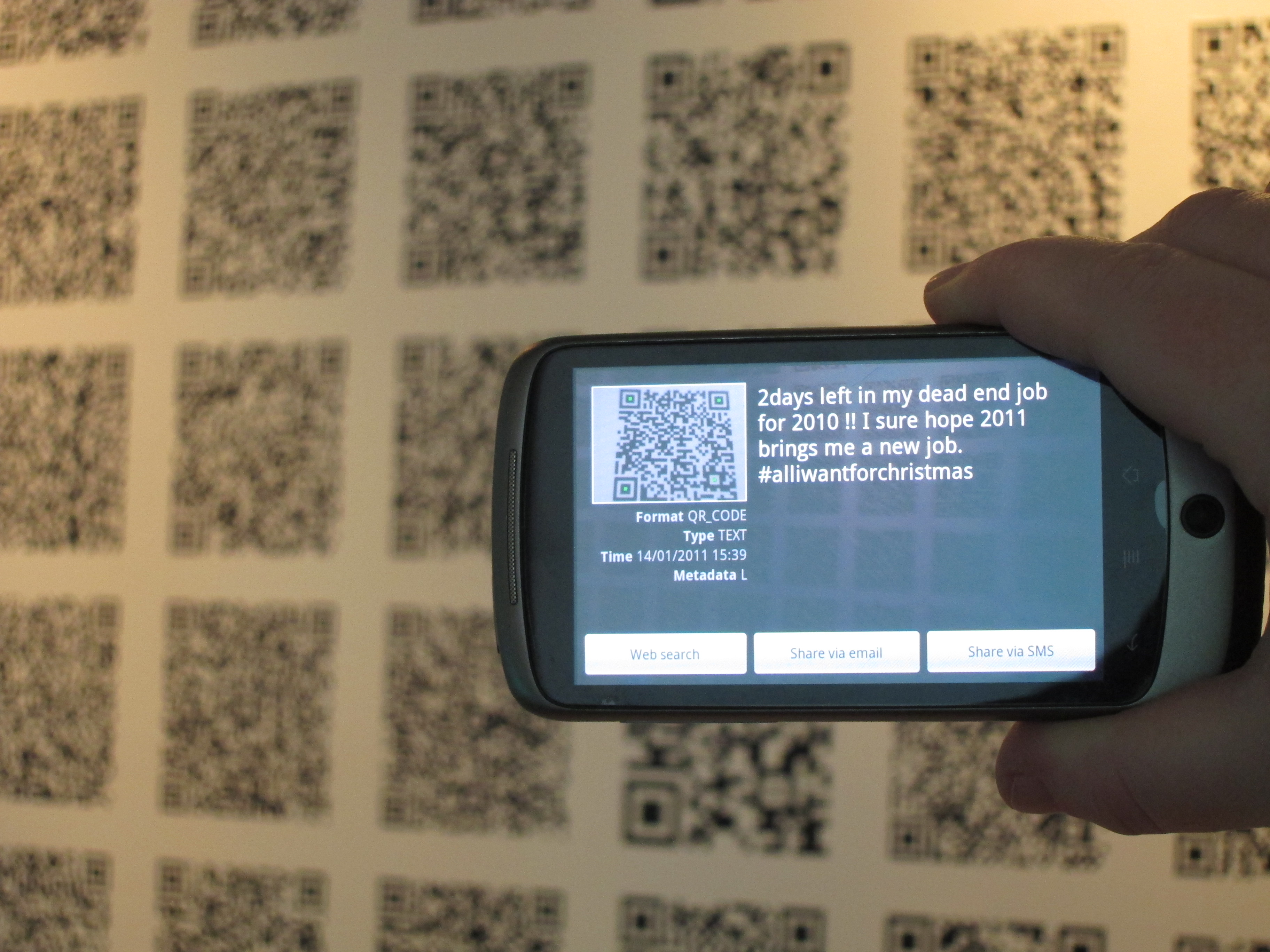 [Translate to English:] Photos from the exhibition "Jsut code" by Winnie Soon and Helen Pritchard. Visitors decoding QR-codes with their smartphones.